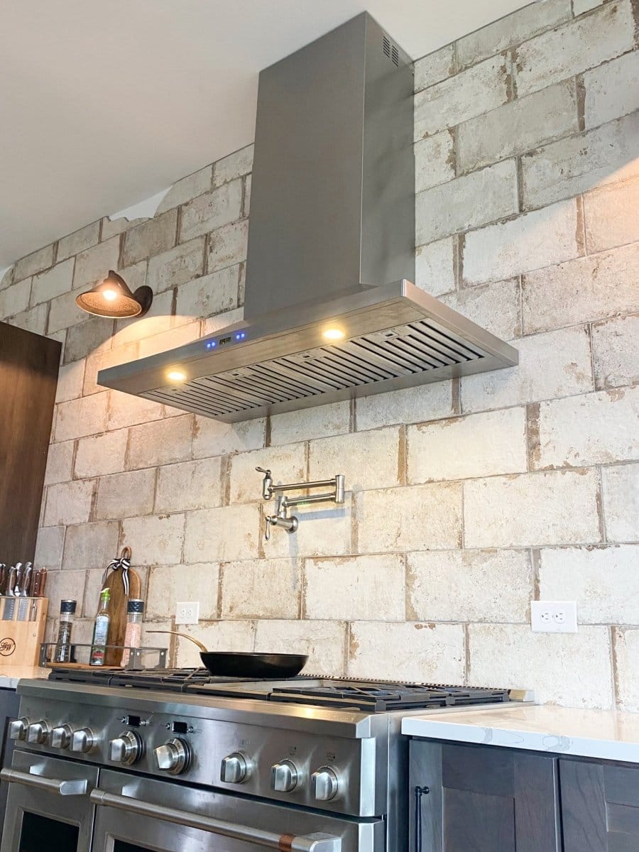 Modern kitchen with stainless stove, ProlineRangeHoods.com Wall Mounted Hood for ventilation (600/1200 CFM), brick wall.