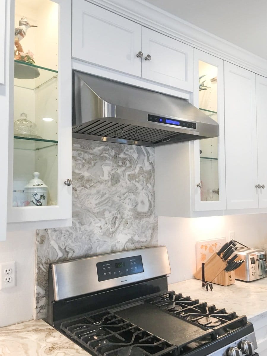 Contemporary kitchen with ProlineRangeHoods.com PLJW 113 Under Cabinet Vent Hood, quiet in stainless steel, white cabinets.