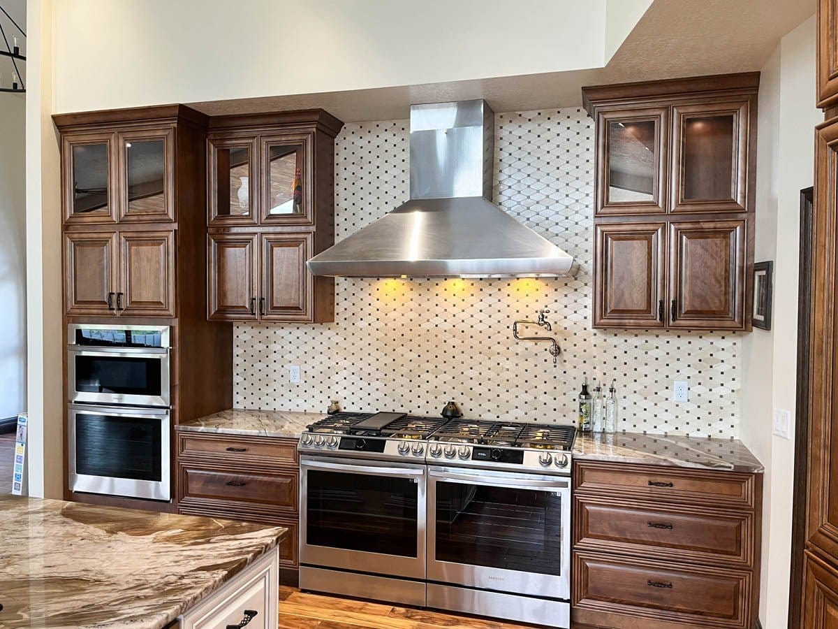 Modern kitchen with double ovens, large range, wood cabinets, Proline PLJW 109 WC hood (1200 CFM), ProlineRangeHoods.com.