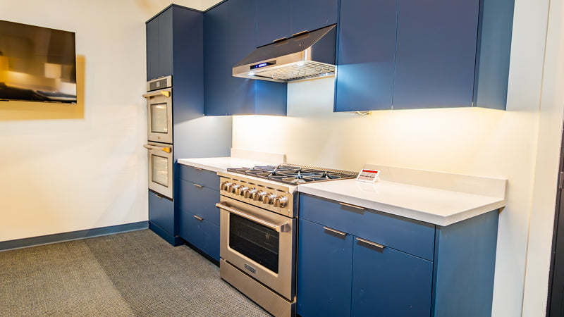 Navy blue kitchen display with ZLINE range and Proline hood