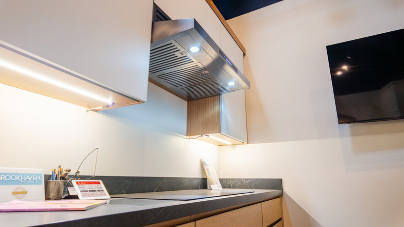 Under-cabinet hood detail with warm showroom lighting