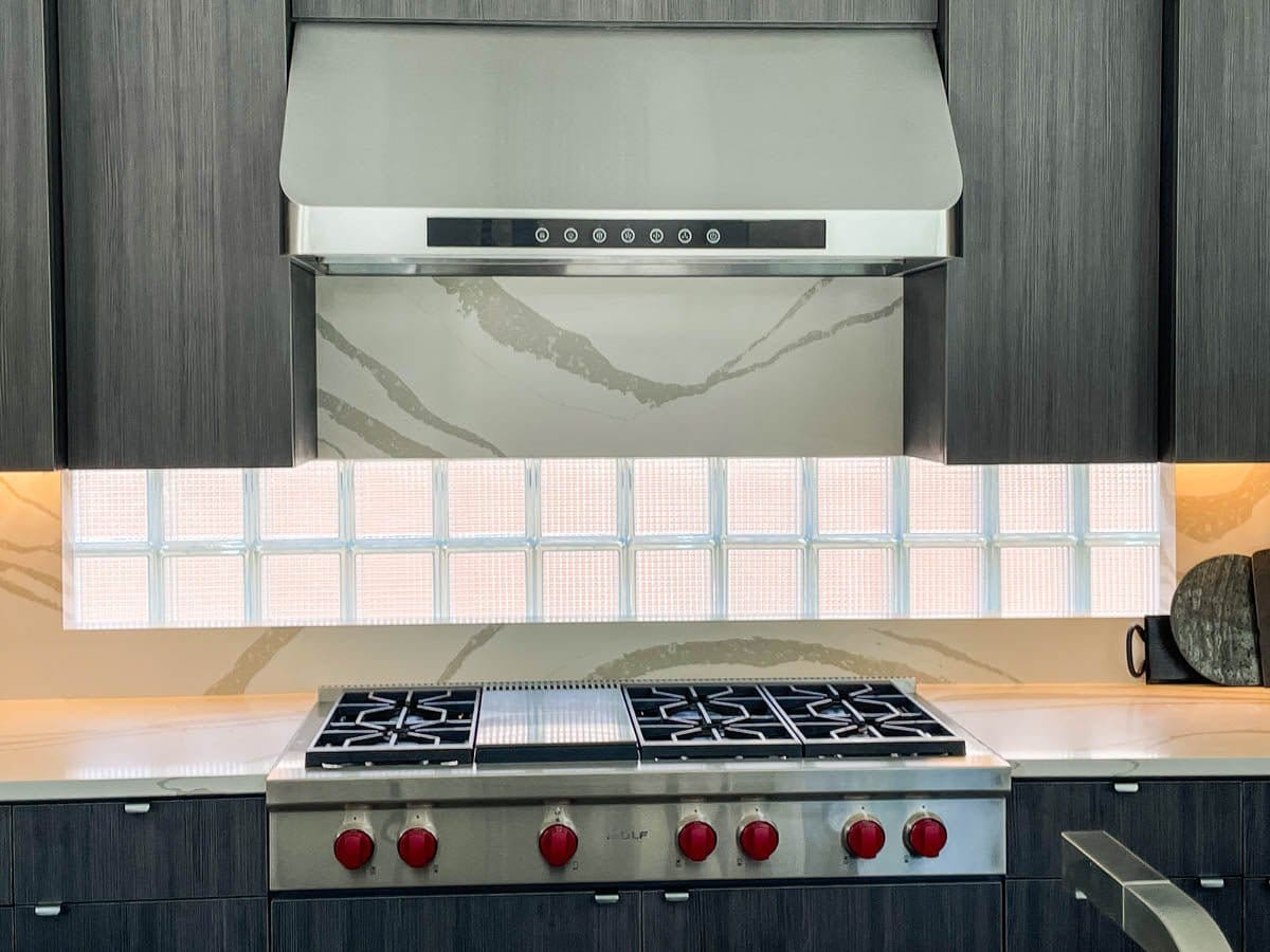Modern kitchen stove with red knobs, Proline PLJW 101 range hood (1000/2000 CFM, stainless), ProlineRangeHoods.com.