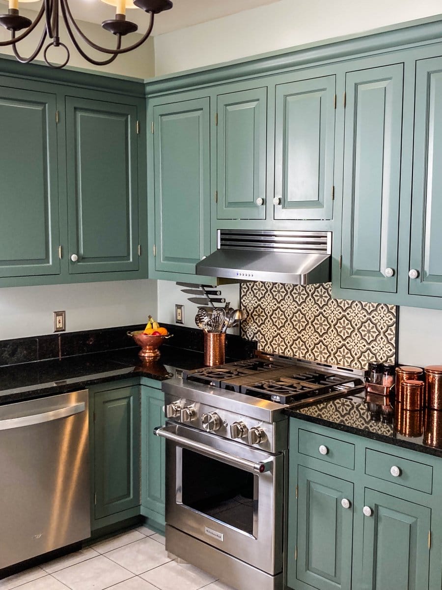 Modern kitchen: green cabinets, black countertops, stainless appliances by ProlineRangeHoods.com with 430 steel finishes.
