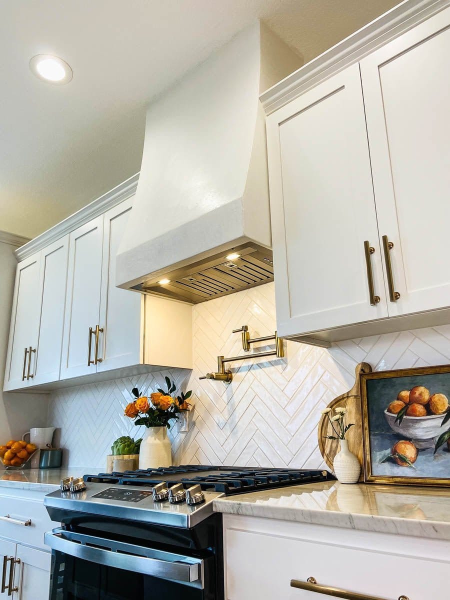 Modern white kitchen featuring a Proline's Insert Range Hood for Custom Range Hoods above a gas stove
